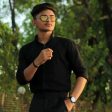 Young Indian male with black shirt and yellow sunglasses posing in the garden